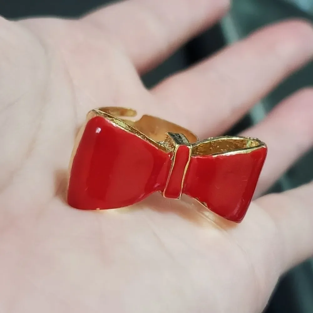 Gold tone red enamel bow ring currently a 7
